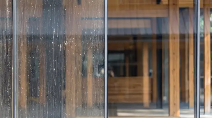 Window glass half streaked with dirt and water marks, half cleaned to perfect clarity